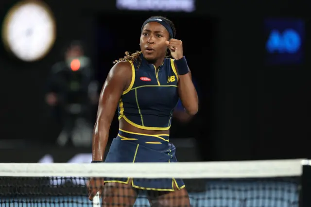 Coco Gauff clenches her fist at the net in celebration