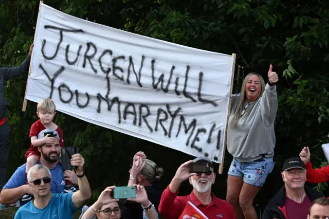 A sign reads 'Jurgen will you marry me?'