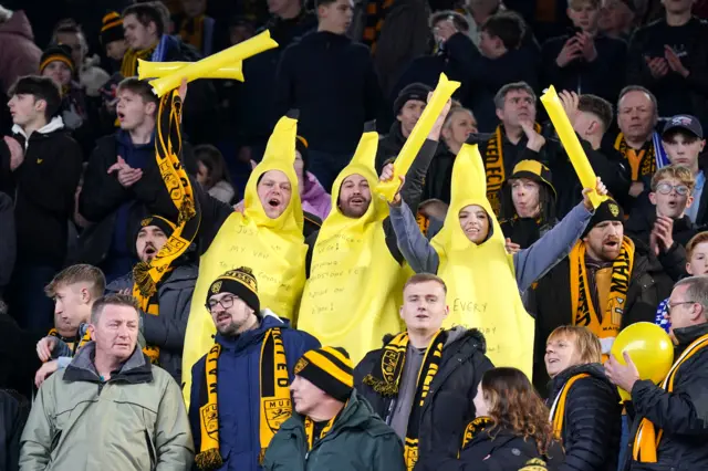 Maidstone fans dressed as bananas stand in their seats before kick off.