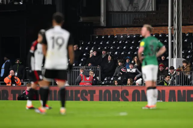 Fulham fans sits in the rapidly emptying stands.