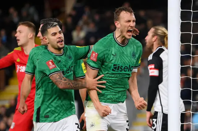 Dan Burn screams in delight at the travelling fans while being congratulated by Bruno Guimaraes.