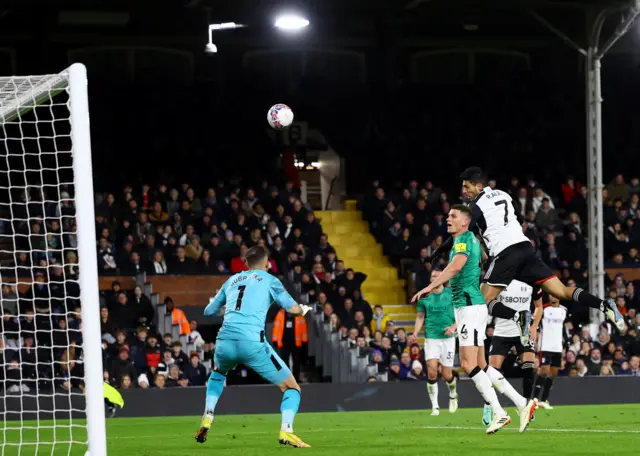 Jimenez leaps highest in the box to head towards goal.