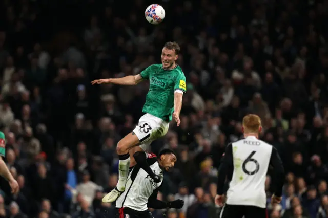 Dan Burn rises above the Fulham attack to win a header.