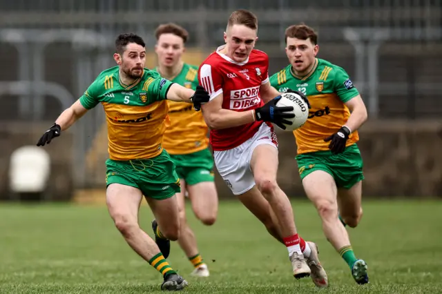 Cork's Luke Fahy attempts to burst away from Ryan McHugh and Brendan McCole