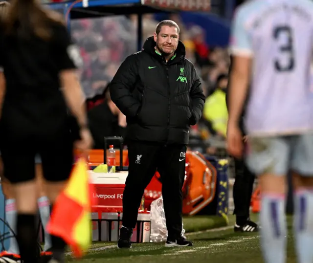 Matt Beard stands with his hands in his pockets on the touchline.