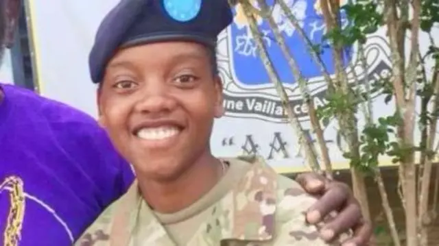 Spc. Kennedy L. Sanders. She is wearing her army uniform and smiling at the camera.