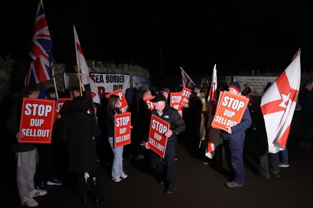 Protesters outside Larchfield estate with "STOP DUP SELL OUT" signs