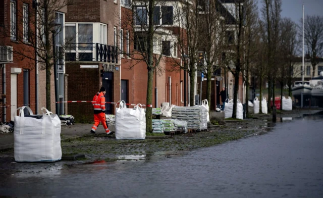 Sandbags are placed in a flooded street near the Markermeer after the first storm of this year, which was named Henk