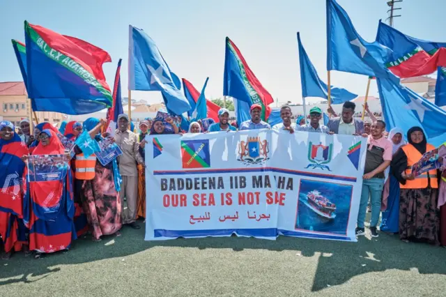 Demonstrators hold banners and flags during a demonstration in support of Somalia's government following the port deal signed between Ethiopia and the breakaway region of Somaliland at Eng Yariisow Stadium in Mogadishu on January 3, 2024