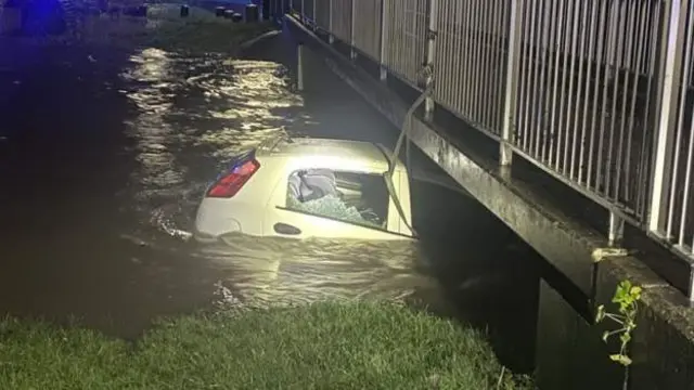 Car trapped under bridge in flooded River Cole