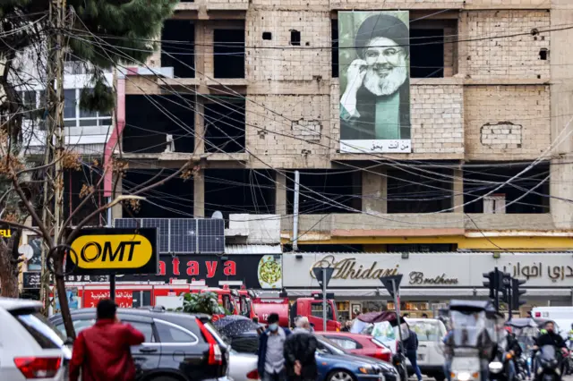 A picture depicting Hassan Nasrallah, the leader of the Lebanese Shiite movement Hezbollah, hangs on a building