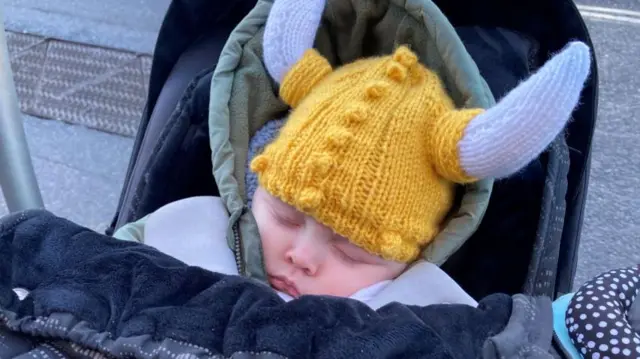 Child in yellow knitted Viking hat sleeping