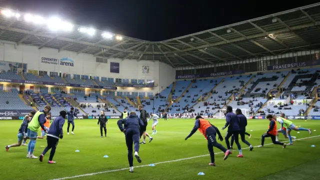 Coventry players warming up on the pitch