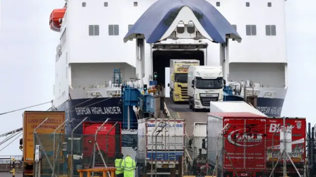 Two trucks disembark a ferry at a good port in Belfast