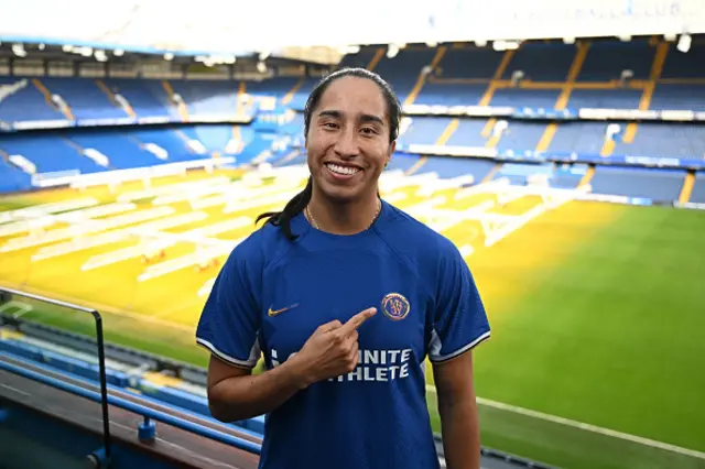 Mayra Ramirez points to the Chelsea badge inside Stamford Bridge