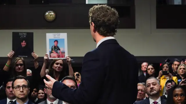 The back of Mark Zuckerberg as he talks to the seated audience