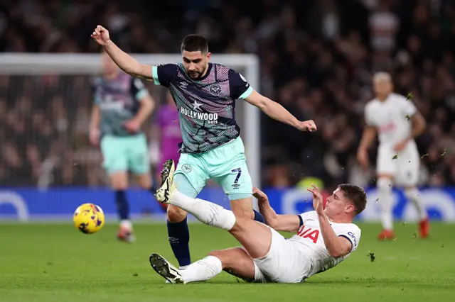 Neal Maupay of Brentford is challenged by Micky van de Ven