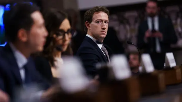 Zuckerberg looks down the line of CEOs, past Yaccarino towards Chew.