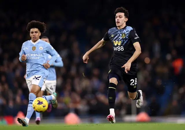 Ameen Al-Dakhil of Burnley chases down the ball whilst under pressure from Rico Lewis