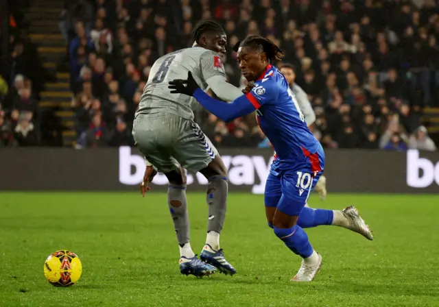 Onana and Eze tussle as the ball rolls loose.