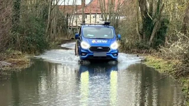 Van drives through flood water