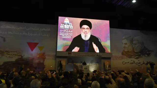 People watch a televised speech of Hezbollah secretary general Hasan Nasrallah, during an event to mark the fourth anniversary of top Iranian commander Qasem Soleimani death, in southern suburb of Beirut, Lebanon, 03 January 2024.