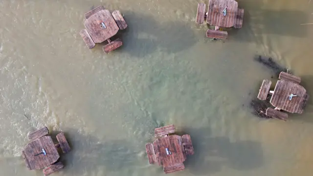 Aerial photos of picnic benches in Bedford that are surrounded by flood water