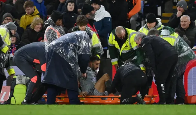 McNeil is helped onto a stretcher by paramedics.