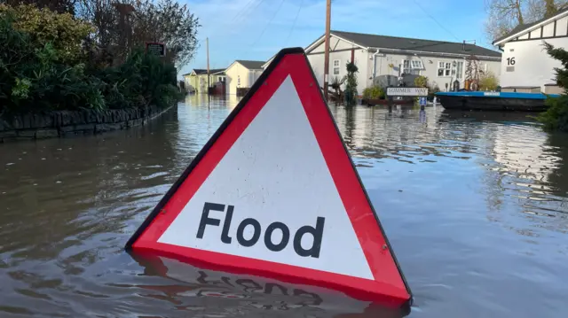 Flood sign in front of flooded homes in Radcliffe on Trent, Nottinghamshire. 4 Jan