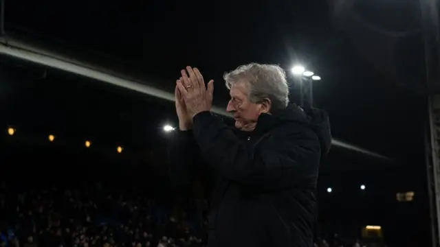 Roy Hodgson claps the Palace fans as he walks across the pitch.