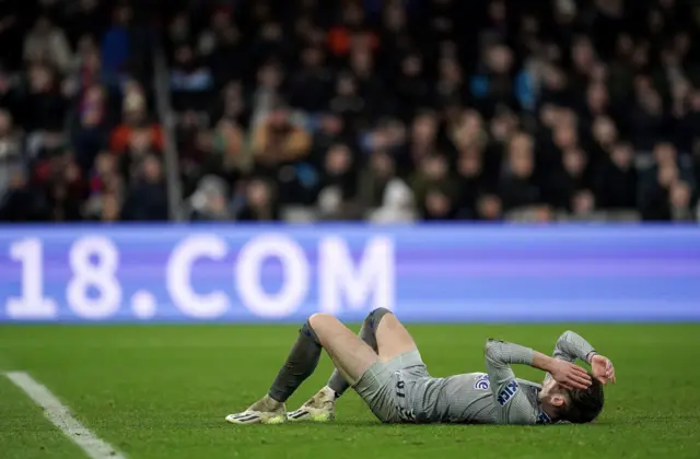 Garner lies on the floor and holds his head after missing a huge chance.