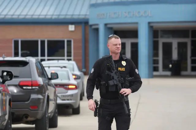 An armed officer outside the school