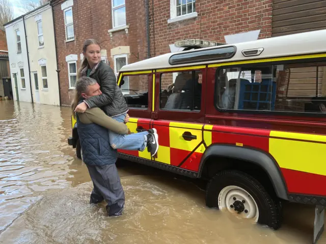 Women is held up after being rescued from high floodwater