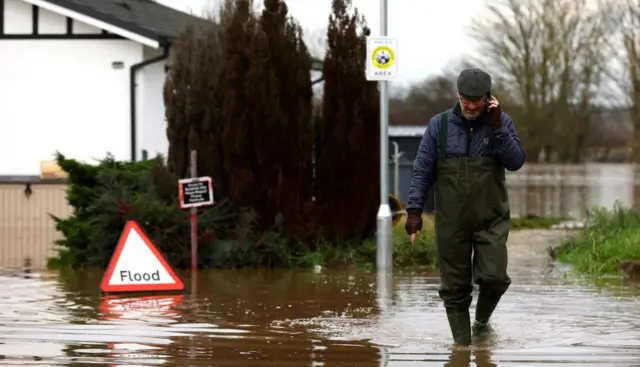 A man walking through floodwater