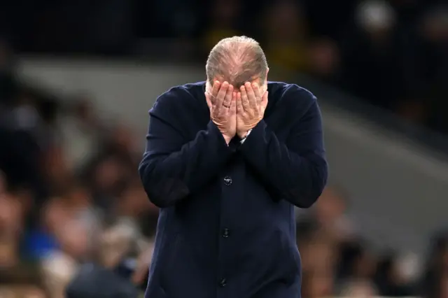 Postecoglou puts his hands to his face in frustration.