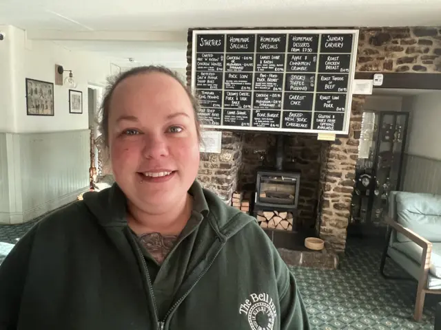 Lady stood in pub which was flooded