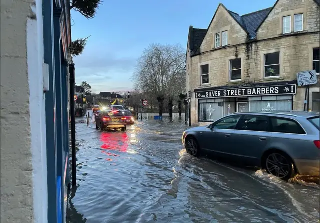 Cars trying to drive through flood water in Bradford-on-Avon