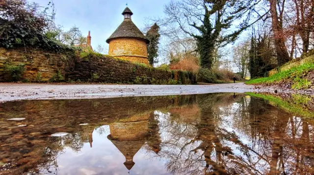 Tower reflected in a puddle in Harlestone, Northamptonshire