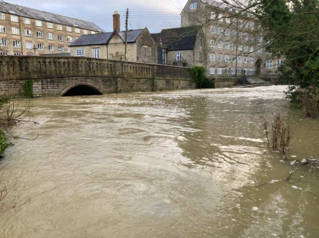 Floodwater rising up Malmesbury bridge