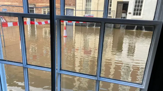 A flooded street seen through a window