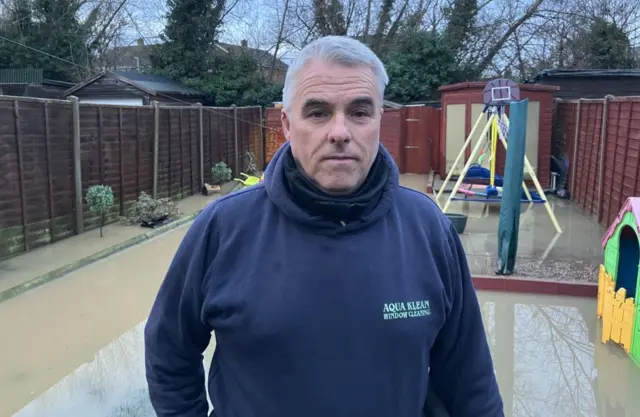 Anthony Molloy, in front of his flooded garden.