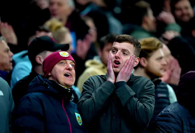 A Burnley fan holds hsi hands to his face.