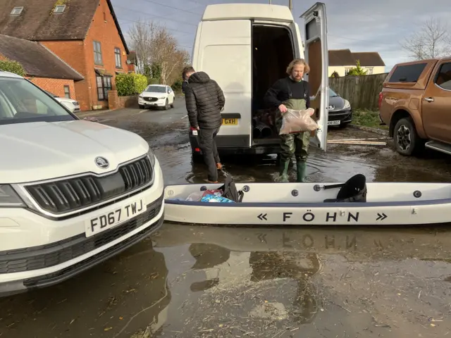 Sandbags being delivered by boats in Longford, Gloucestershire