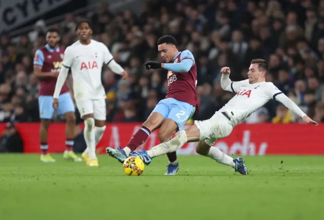 Lo Celso challenges Ramsey as he looks to pass the ball off.