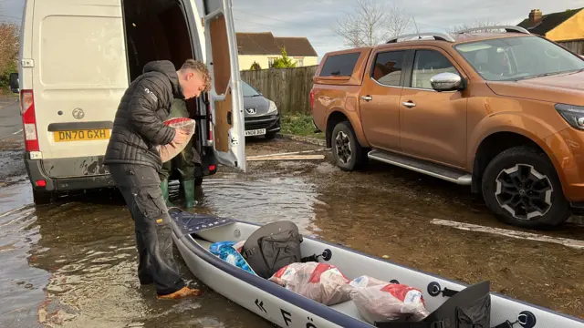 Sandbags being delivered by boats in Longford, Gloucestershire