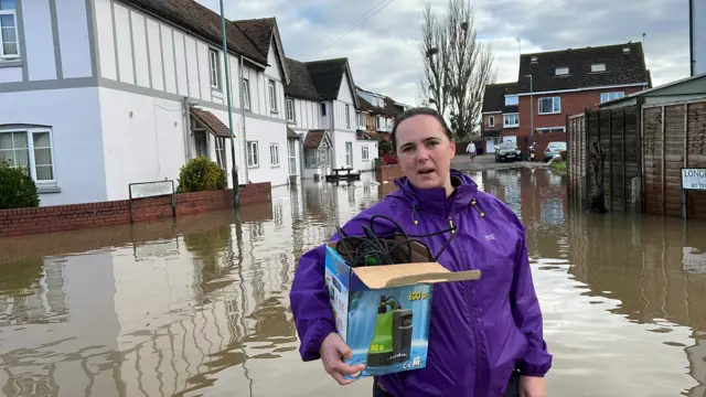 Lady stood outside homes in flood water