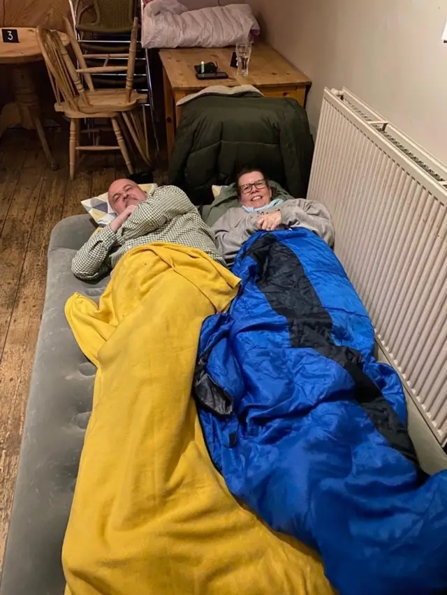 People in airbeds and sleeping bags on the pub floor