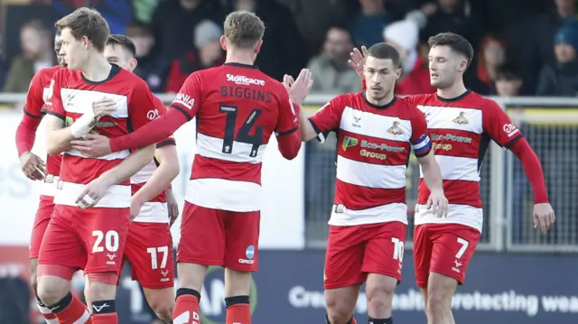 Doncaster players celebrate equalising against Harrogate