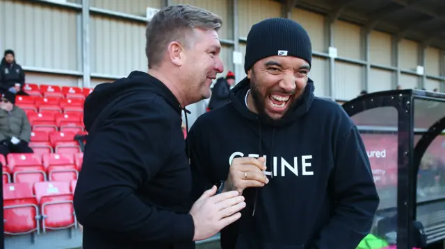 Karl Robinson, manager of Salford City and Forest Green boss Troy Deeney share a joke ahead of kick-off between the sides