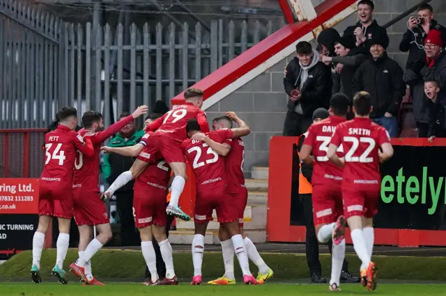 Cheltenham players celebrate a goal against Portsmouth